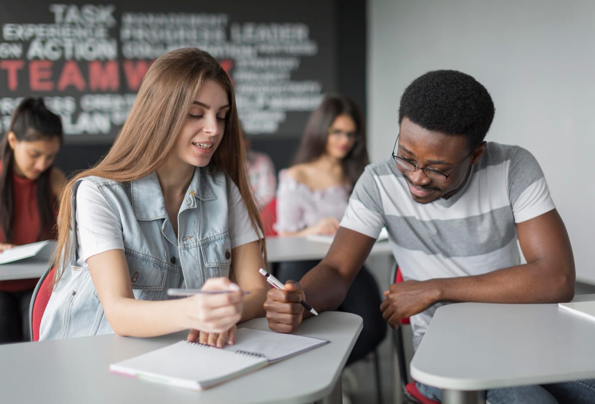 Estudantes sentados em carteiras durante uma prova