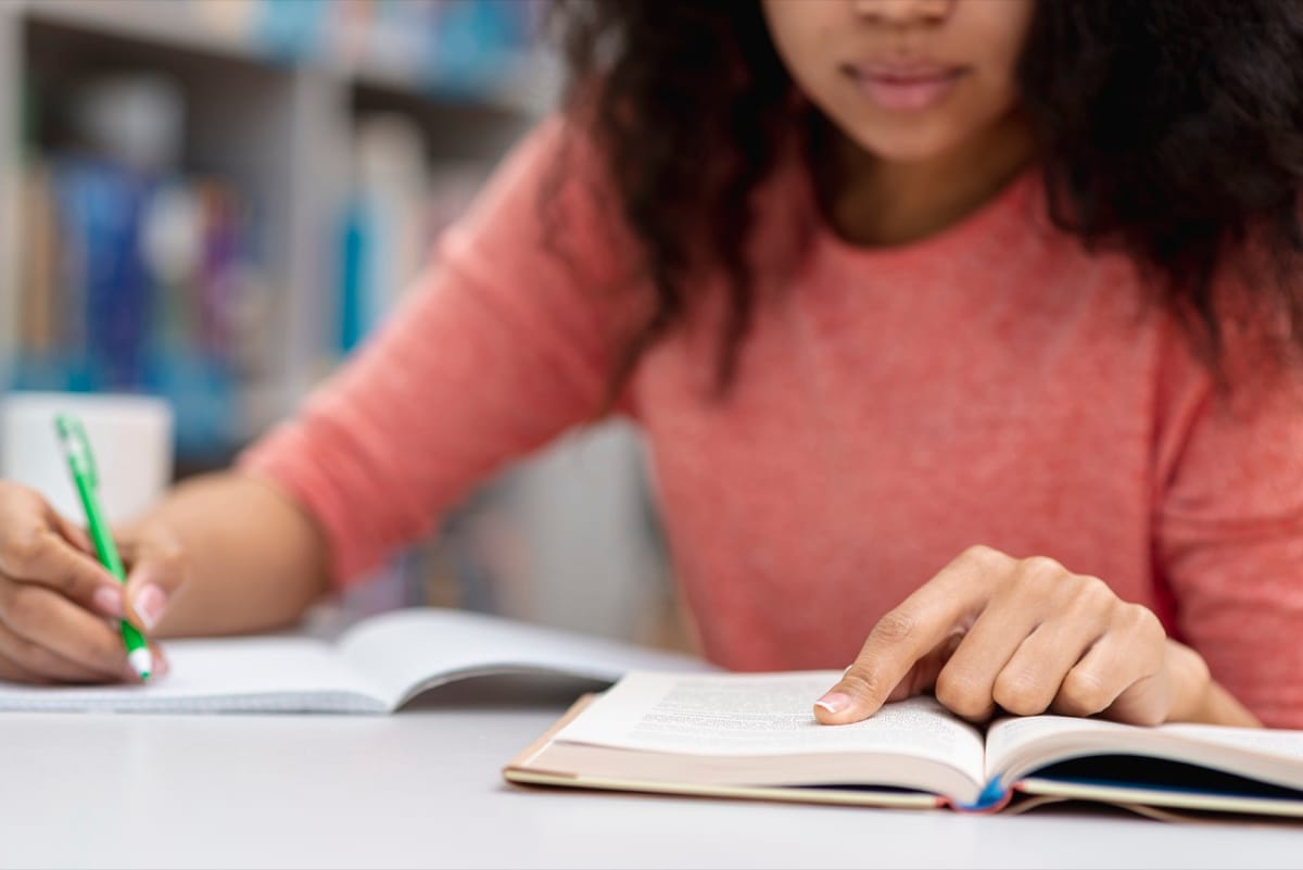 Estudante lendo um livro na biblioteca